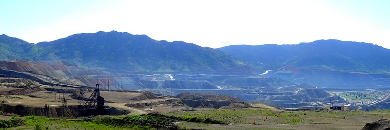 The Continental Open Pit mine in Butte, Montana, is located within view of the Continental Divide.  The reopening of the Continental Pit in 2003 revitalized the community of Butte and remains the only operational mine in the area.  (https://www.deseretnews.com/article/595076167/Mine-reopening-lifts-battered-Butte.html)    The mining dump truck has a 240 ton capacity.  It hauls ore to the crusher and waste to a designated rock repository.    As of 2006, remaining ore reserves at the Continental pit were estimated to be 364 million tons, averaging 0.35 percent copper, 0.027 percent molybdenum, and 2.2 g/tonne silver.    From 1880 through 2005, the mines of the Butte district have produced more than 9.6 million metric tons of copper, 2.1 million metric tons of zinc, 1.6 million metric tons of manganese, 381,000 metric tons of lead, 87,000 metric tons of molybdenum, 715 million troy ounces (22,200 metric tons) of silver, and 2.9 million ounces (90 metric tons) of gold.